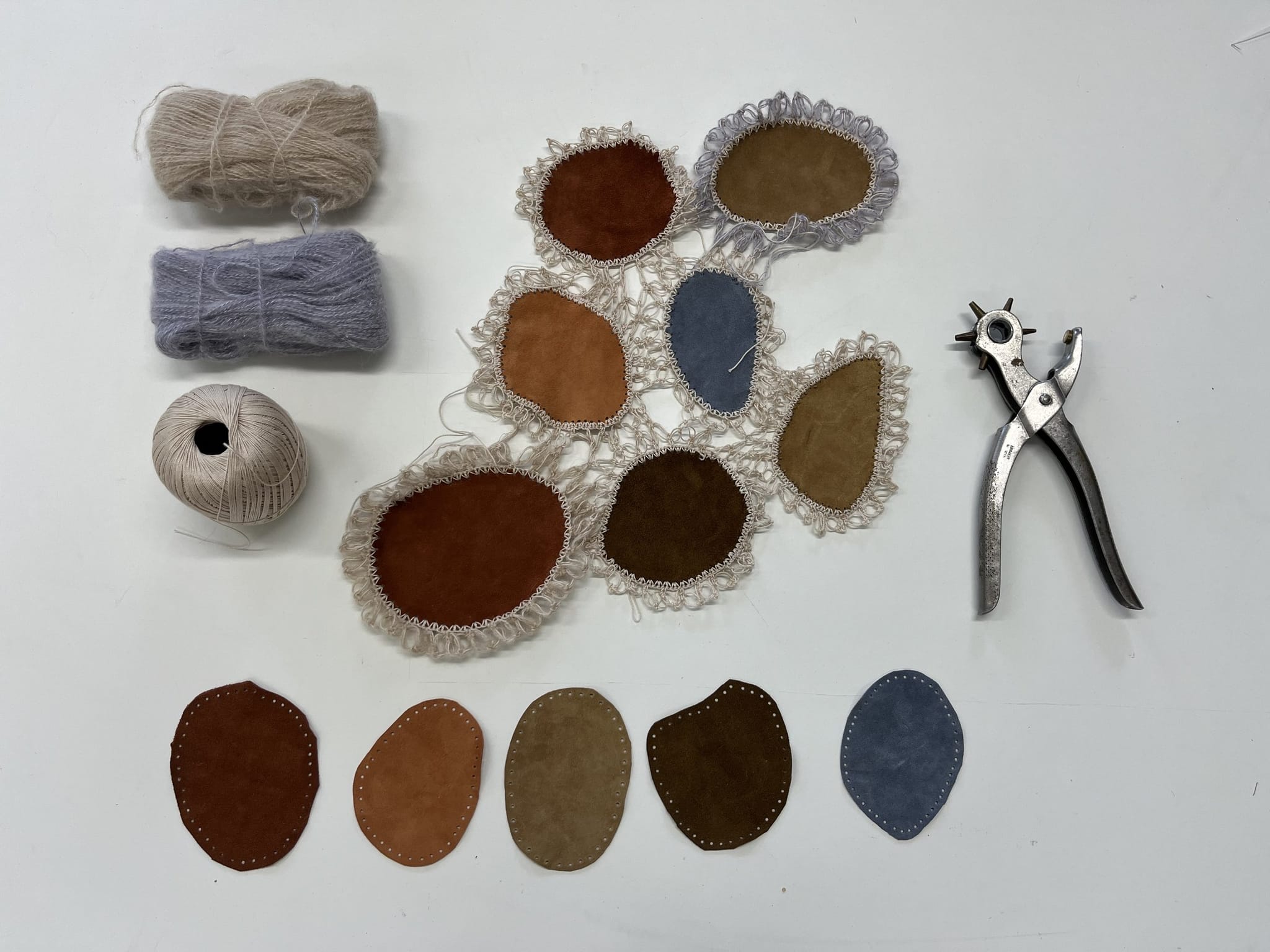 Gelochte Lederpatches, Mohairgarn und eine Revolverlochzange