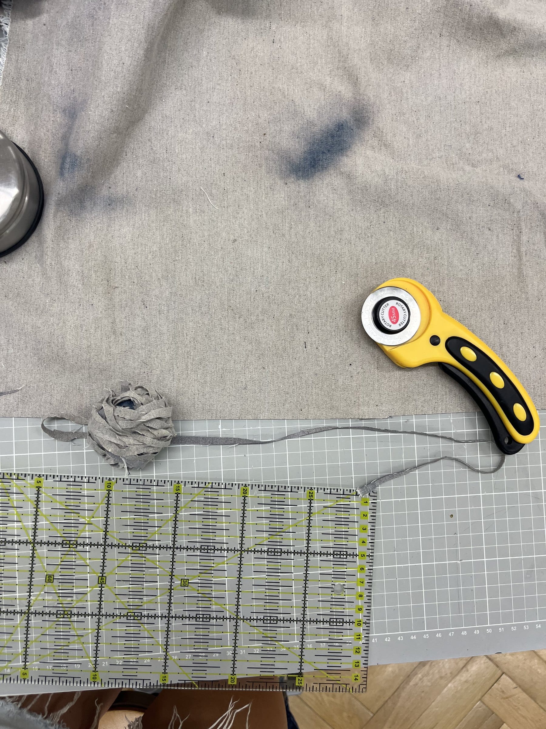 Gefärbter Denim auf der Schneidematte mit Rollschneider und Lineal